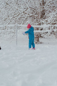 Full length of woman skiing on snow covered field