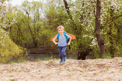 Full length of boy standing in forest