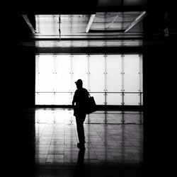 Rear view of silhouette man walking in building