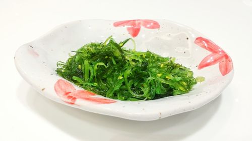 Close-up of salad in plate against white background