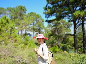 Portrait of smiling woman standing in forest