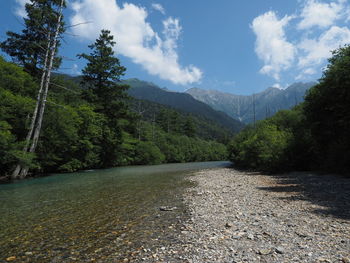 Scenic view of river and mountains against sky