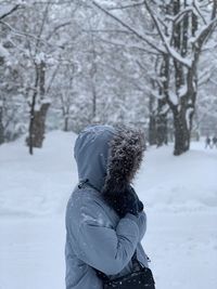 Rear view of woman standing on snow covered field