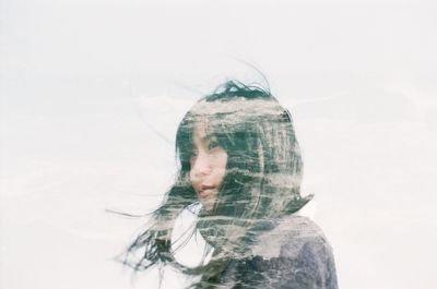 Double exposure of young woman and sea against white background