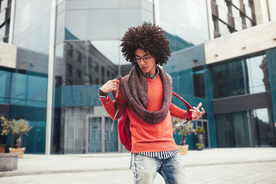 Young man wearing backpack while standing on street