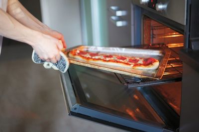 Midsection of man preparing food in kitchen at home