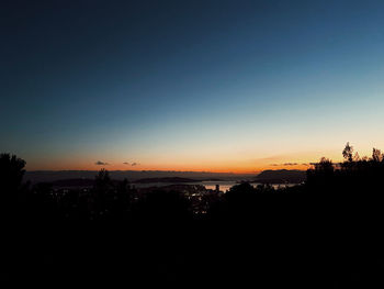 Silhouette trees against clear sky during sunset