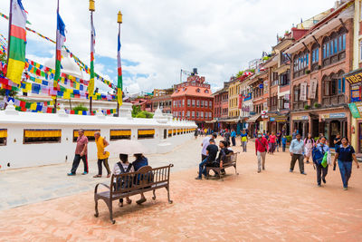 Group of people in park against buildings in city