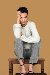 Portrait of young woman sitting on sofa at home