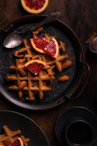 Waffles with orange on a plate, flat lay