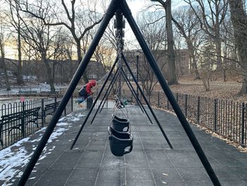 Kid on swing playground in park during winter