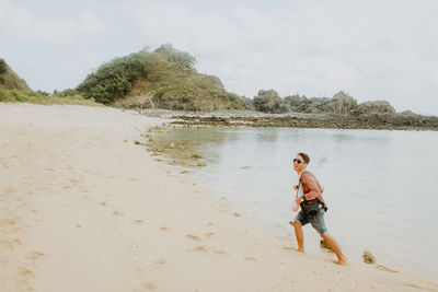 Full length of boy on beach against sky