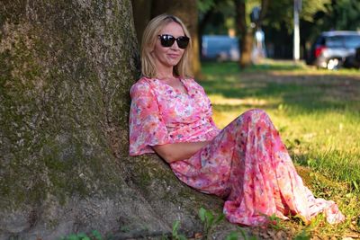 Woman wearing sunglasses sitting on grass