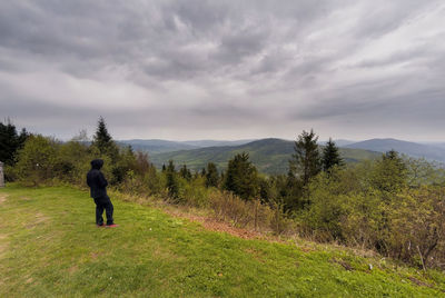 Rear view of man on field against sky