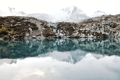 Scenic view of lake by mountains against sky