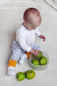 High angle view of baby sitting on table
