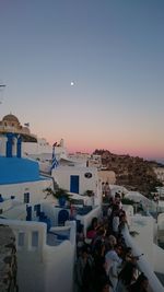 People at beach against sky during sunset