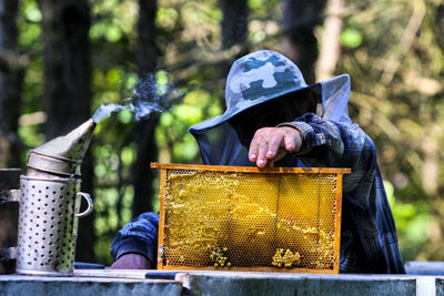 Man reaching beehive