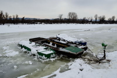 Boats on the frozen river covered with snow and ice