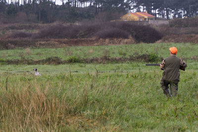 Rear view of man standing on grassy field