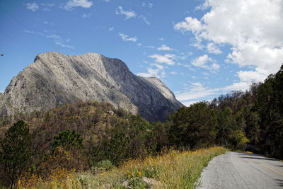 Road by mountain against sky