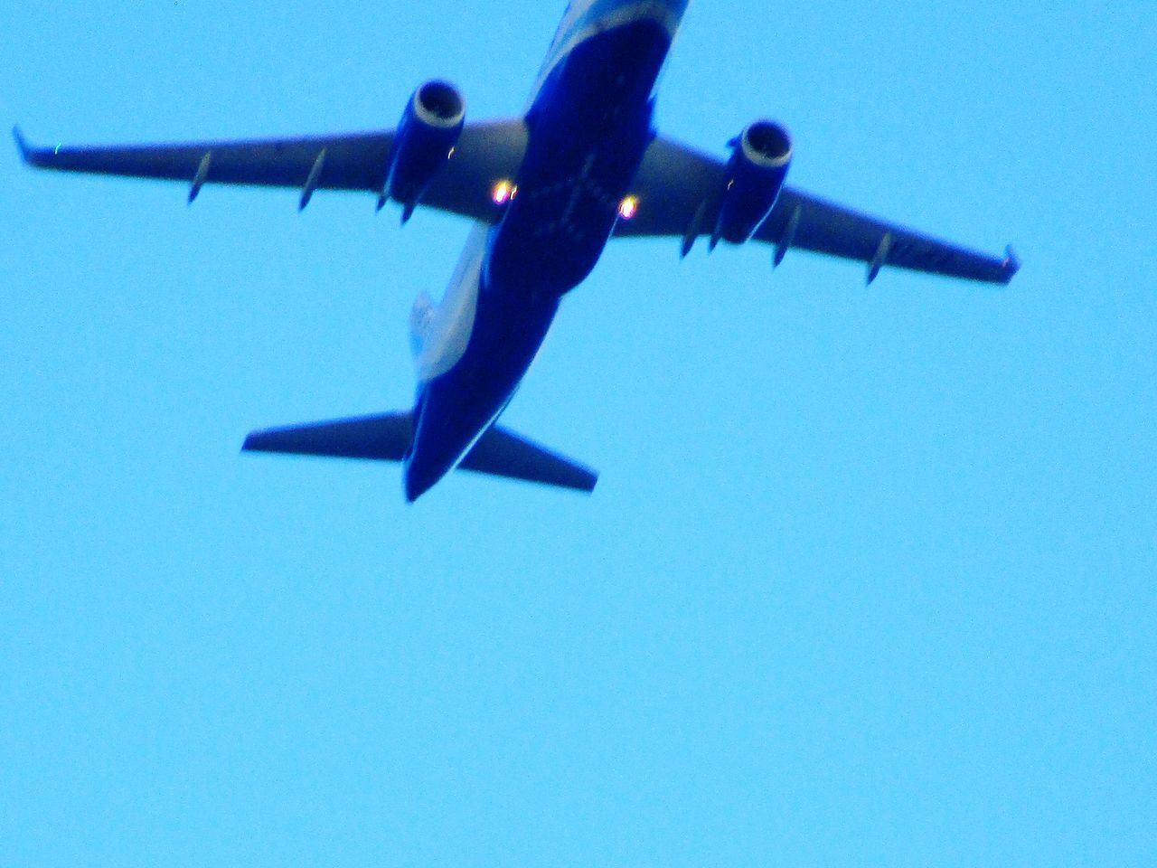 LOW ANGLE VIEW OF AIRPLANE AGAINST CLEAR BLUE SKY