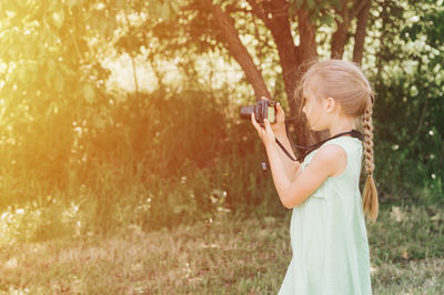 Side view of child holding camera