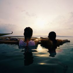 Rear view of women swimming in sea