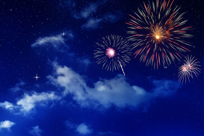 Low angle view of fireworks against sky at night