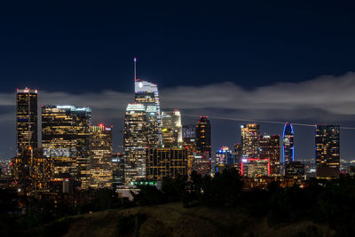 Illuminated buildings against sky at night