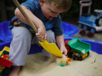 Boy playing with sand and toys at playground