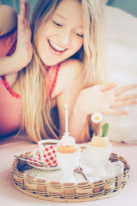 Close-up portrait of surprised woman looking at cupcake