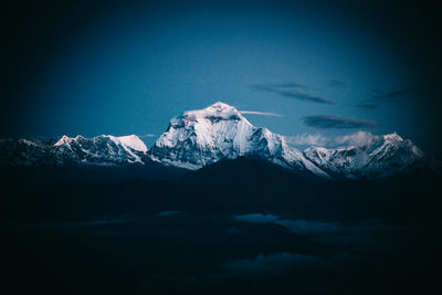 Scenic view of snowcapped mountains against blue sky