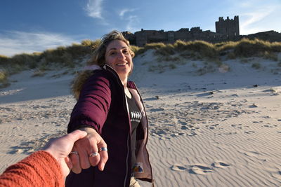 Cropped hand of person holding smiling woman hand outdoors