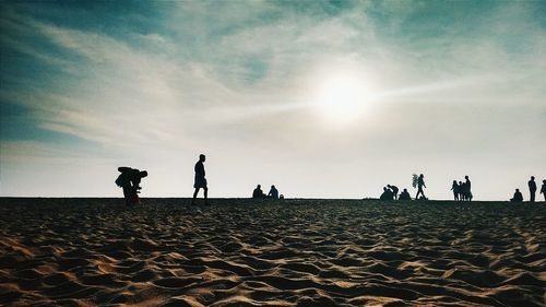 Silhouette people on sandy beach