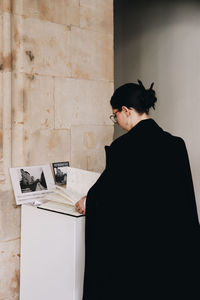 Side view of man standing against wall