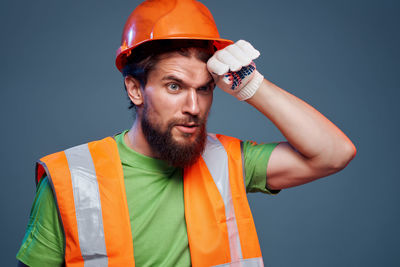 Portrait of man standing against gray background