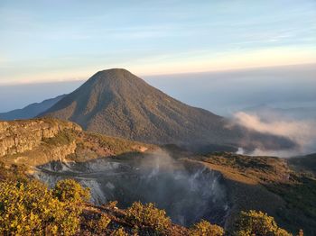 Scenic view of volcanic mountain against sky during sunset