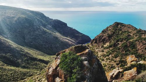 Scenic view of sea and mountains against sky