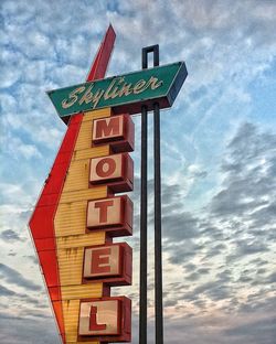 Low angle view of road sign against sky