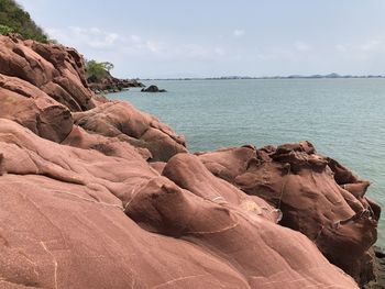 Rock formations by sea against sky