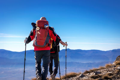 Two hikers reach the summit of mountains in abruzzo, italy.