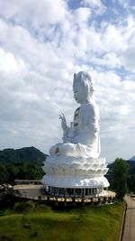 Statue against temple against sky