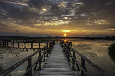 Pier over sea against sky during sunset