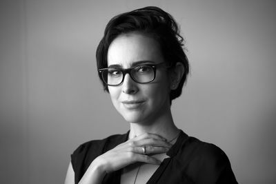 Portrait of smiling young woman against wall