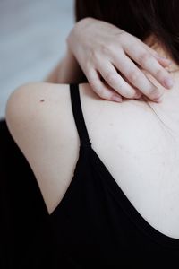 Close-up of woman hand over black camisole