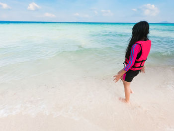 Full length of woman on beach against sky
