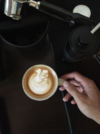 Cropped image of hand holding coffee cup