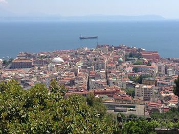 Boats in sea with cityscape in background