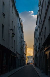 Road amidst buildings in city against sky